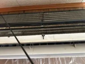 Dirty heat pump unit in Lincoln, Maine before professional deep cleaning service.